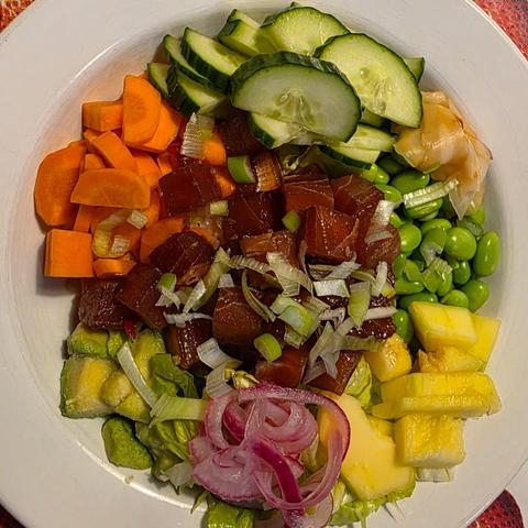 En tallrik tonfisk, sallad, morot, edamamebönor, avokado, mango, rödlök och gurka. Riset syns inte på bilden.