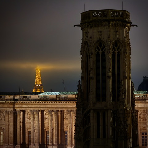 Eiffeltornet, Louvren och Tour Saint-Jacques en mörk novemberkväll. 