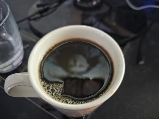 A cup of black coffee reflecting the singer from Falling in Reverse from the video "Watch the World Burn".