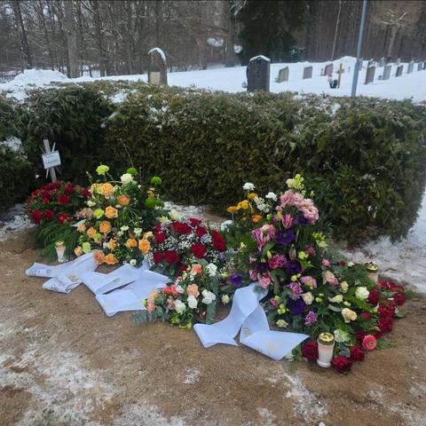 A new grave covered in roses.