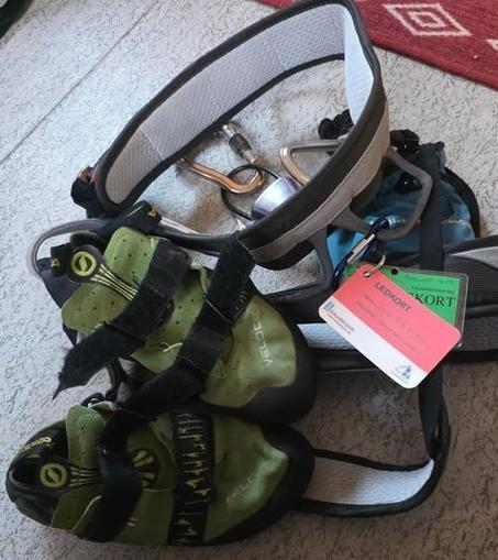 A climbing harness, climbing shoes and two certification cards for lead and top-rope climbing.