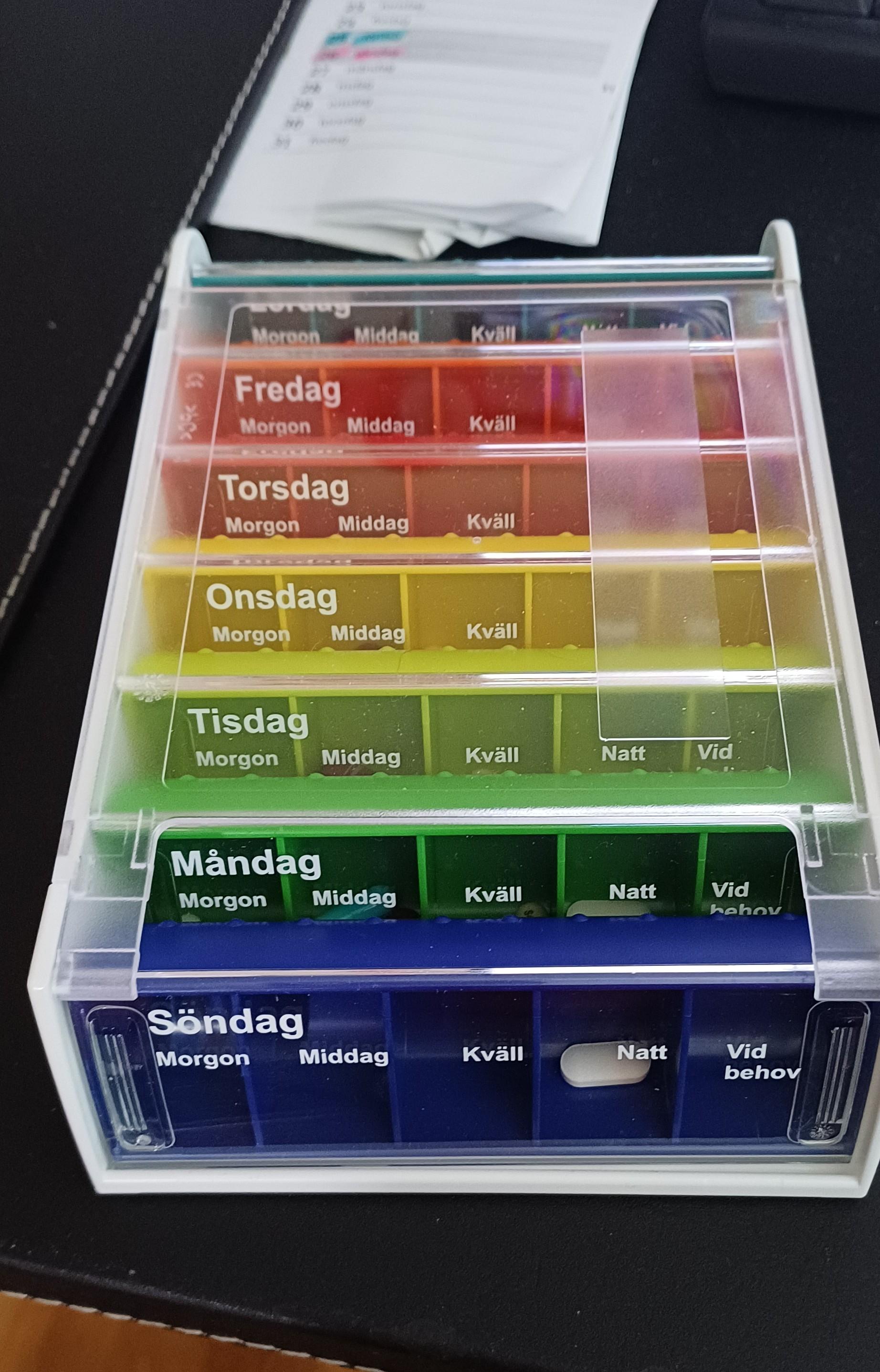 En dosett för sju dagar med medicin. Regnbågsfärgad.