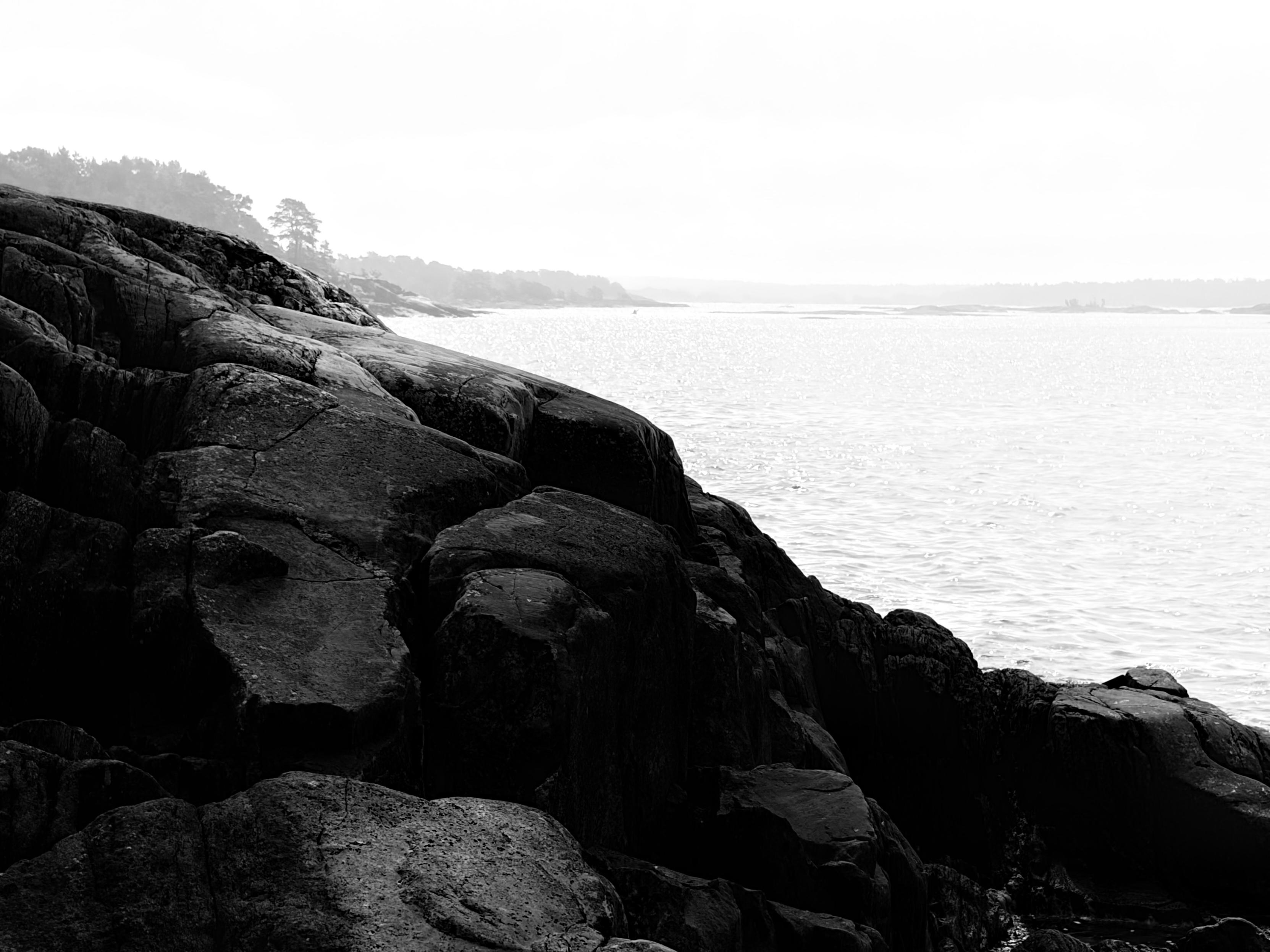 Black and white photo of cliffs by the sea formed by ice