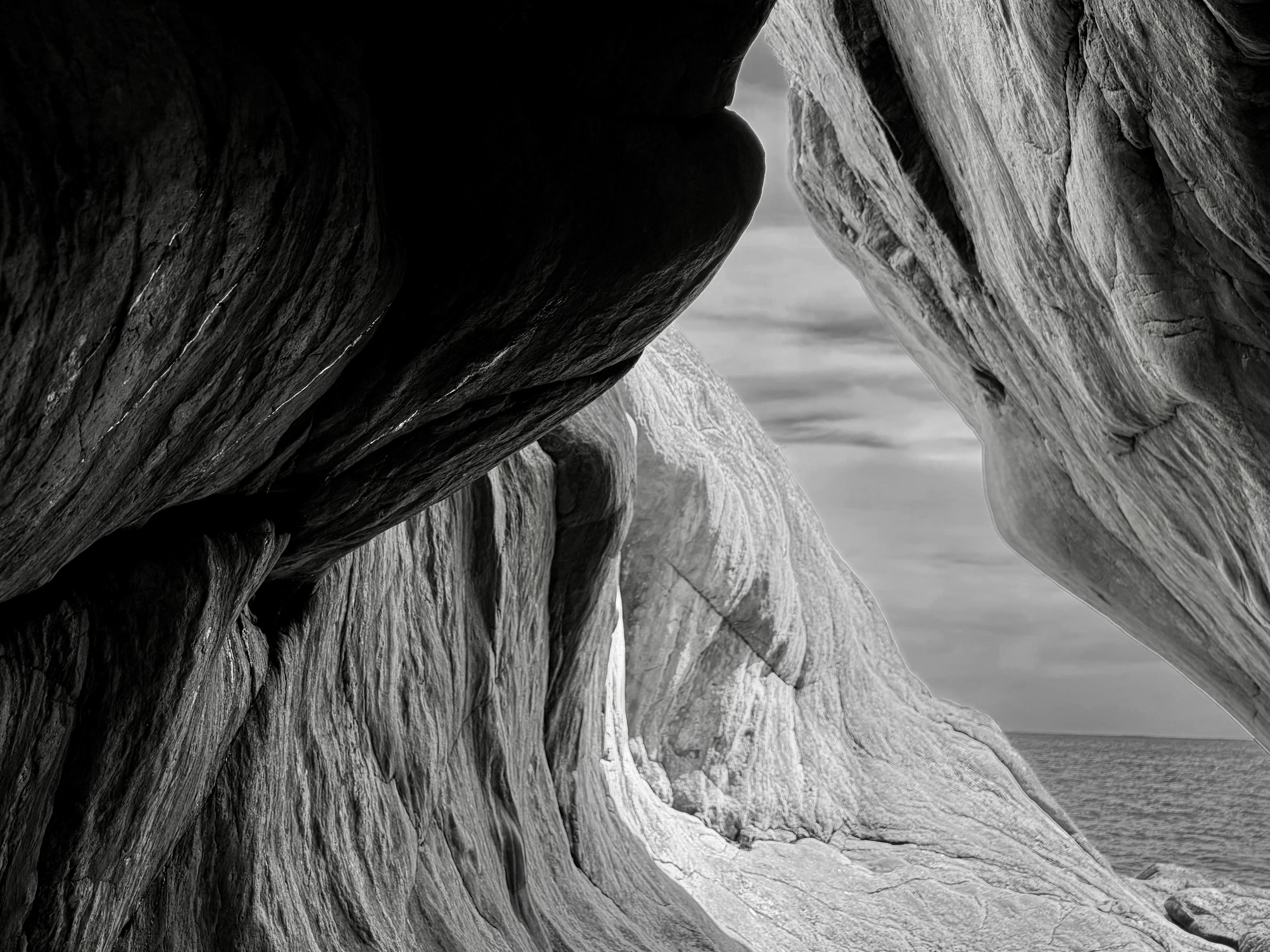 Black and white photo from inside a cave formed by the sea