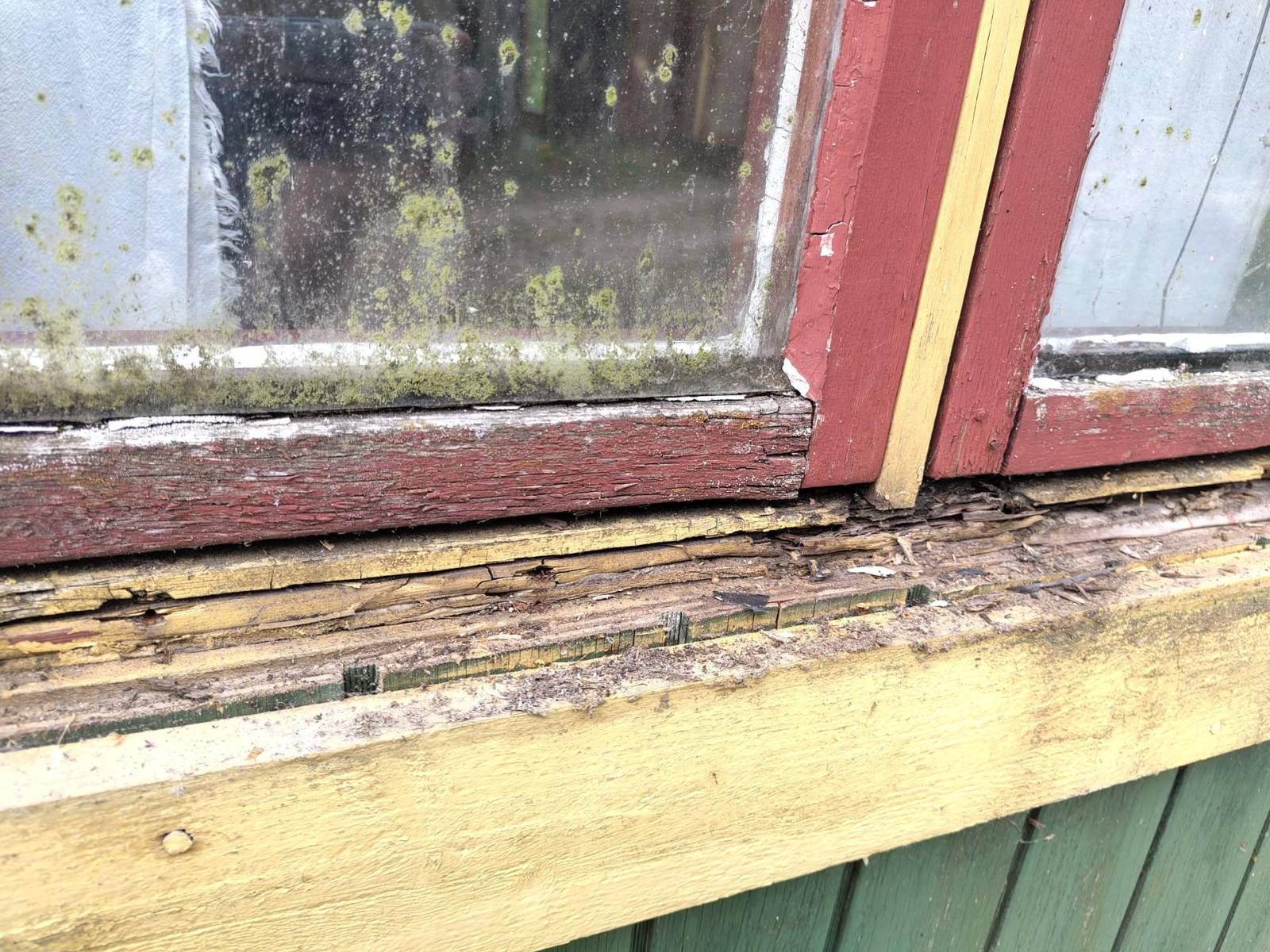 A sad window with parts rotting out